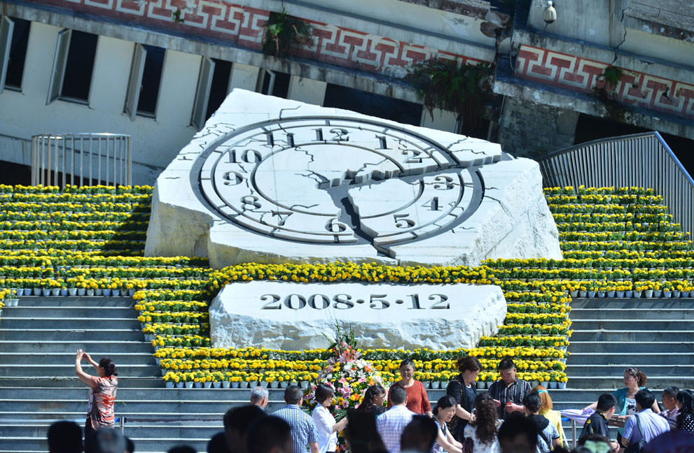 Люди собираются перед памятником на 5-ую годовщину землетрясения в поселке Инсю, уезд Вэньчуань, провинция Сычуань, Китай, 12 мая 2013