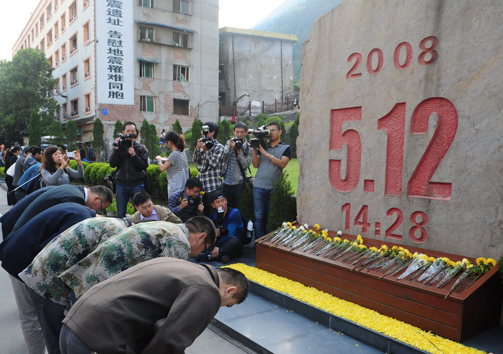Люди скорбят по жертвам землетрясения перед мемориалом в Бэйчуане